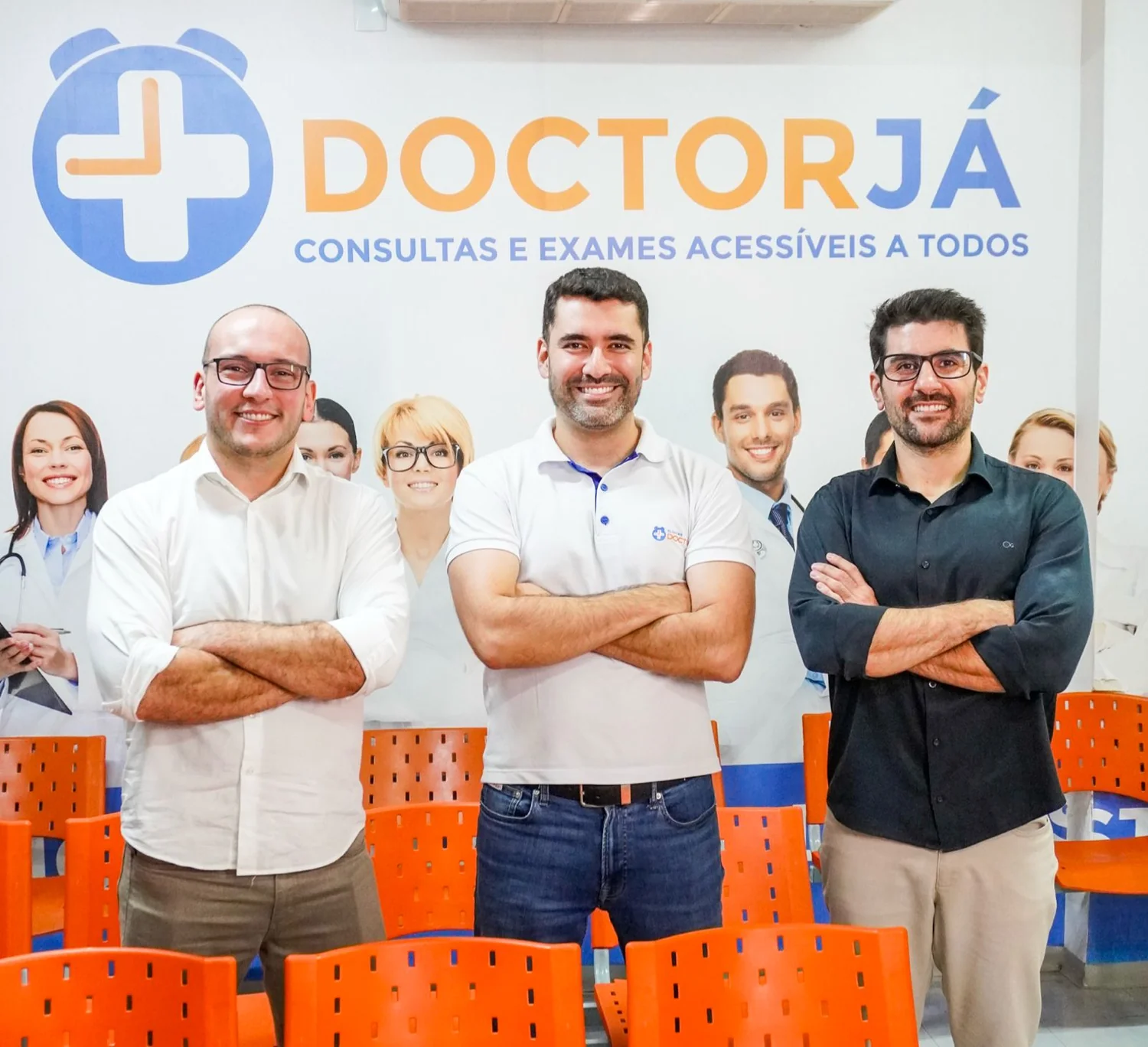 Equipe médica das Clínicas Doctor Já, na frente do painel da recepção